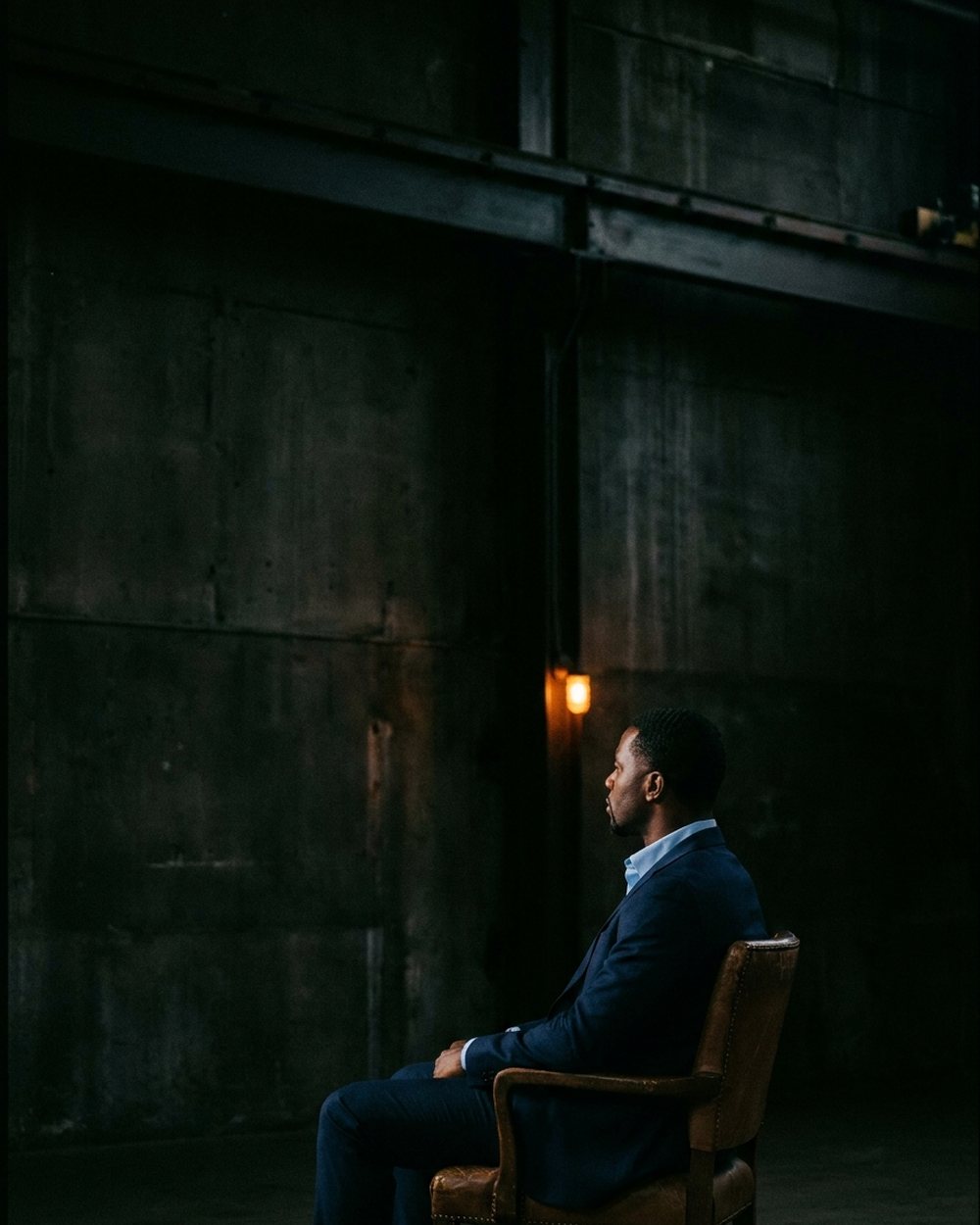 Khajeel Bailey, founder of StartRiteNow, seated in a dark studio